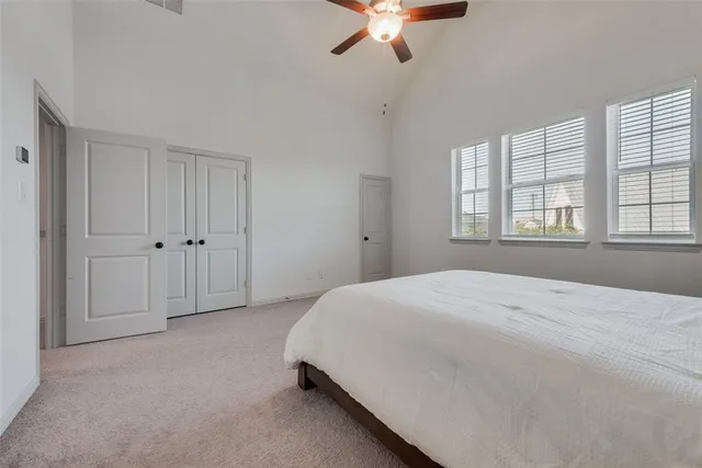 a spacious bedroom with a bed and a chandelier