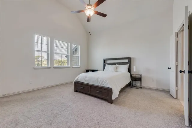 a spacious bedroom with a bed and a chandelier