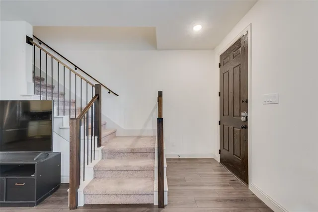 a view of hallway with stairs and wooden floor