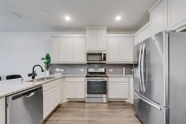 a kitchen with a refrigerator sink and stainless steel appliances