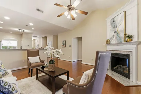 a living room with furniture a chandelier and a fireplace