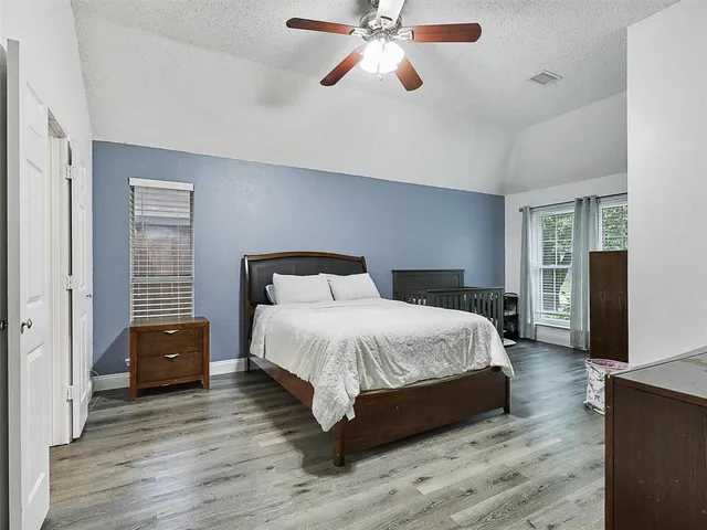a bedroom with a bed and wooden floor