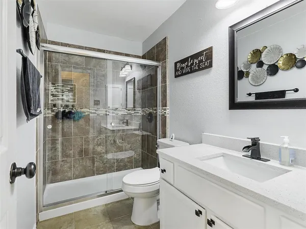 a bathroom with a sink toilet and shower