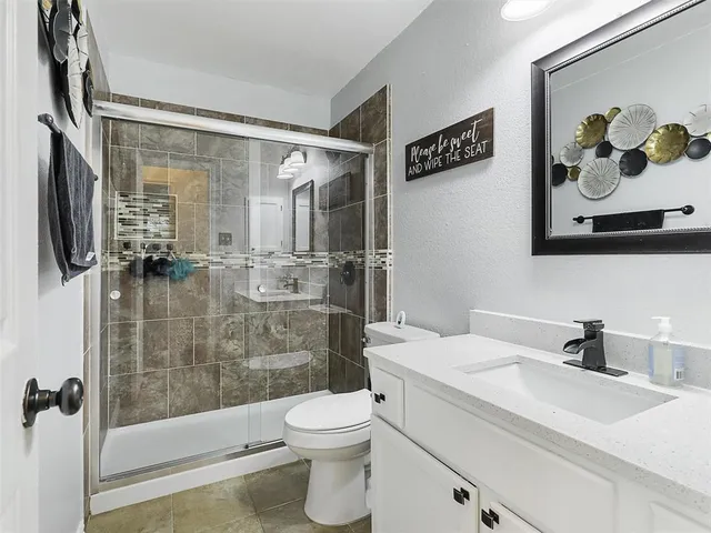 a bathroom with a sink toilet and shower
