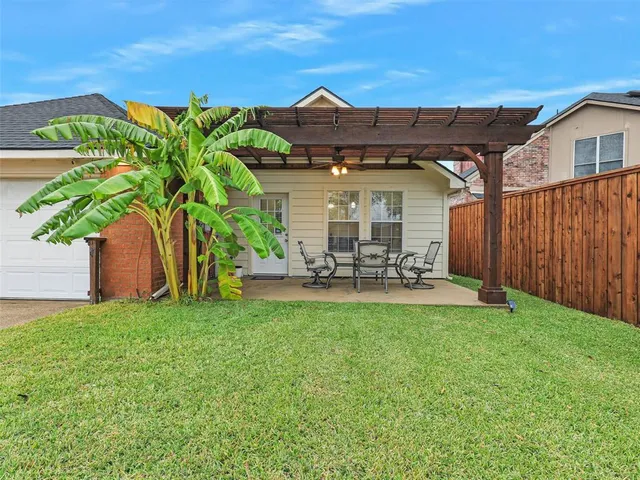 a view of a patio with table and chairs and a large tree