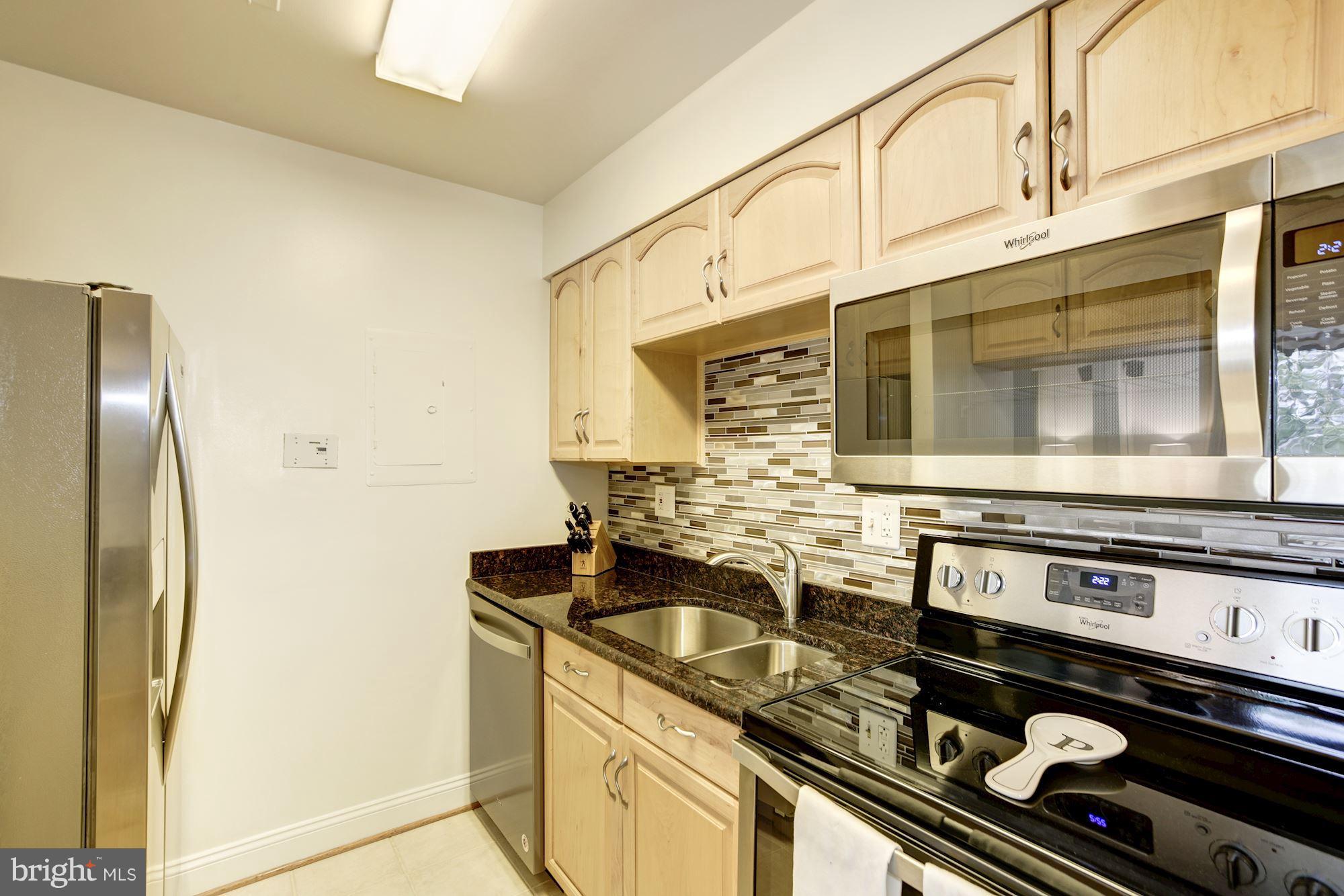 1808 Old Meadow Road, Unit 1403 McLean, VA 22102 - Photo 6 of 30 a kitchen with a stove and a microwave