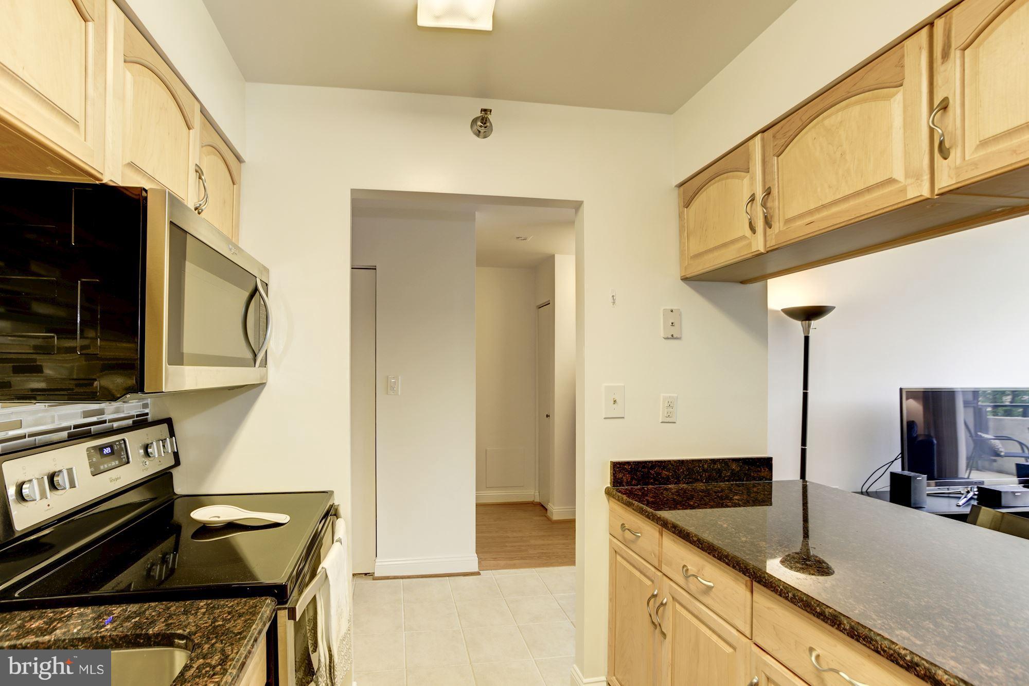 1808 Old Meadow Road, Unit 1403 McLean, VA 22102 - Photo 8 of 30 a kitchen with granite countertop a sink a stove and refrigerator