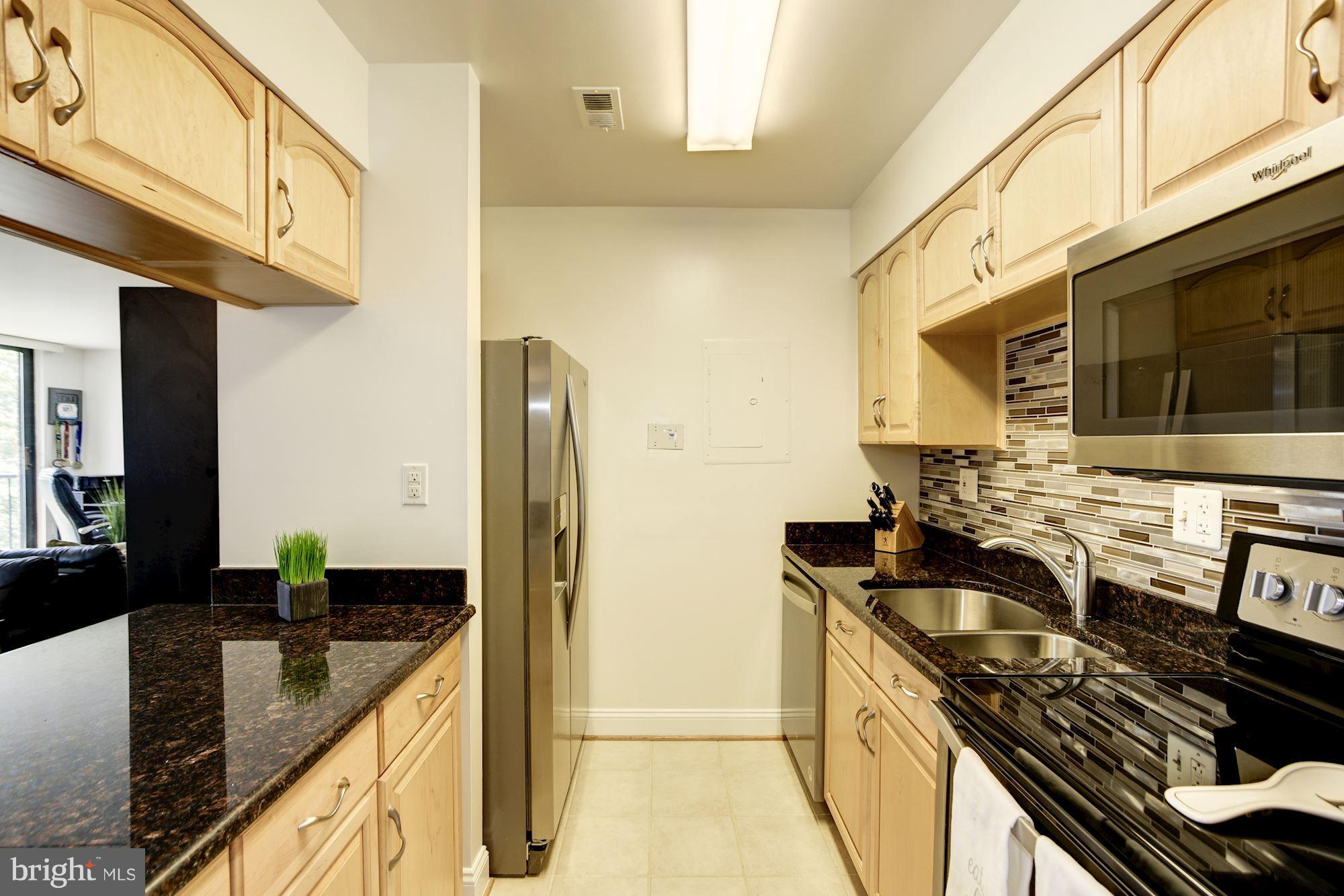 1808 Old Meadow Road, Unit 1403 McLean, VA 22102 - Photo 9 of 30 a kitchen with stainless steel appliances granite countertop a sink stove and refrigerator
