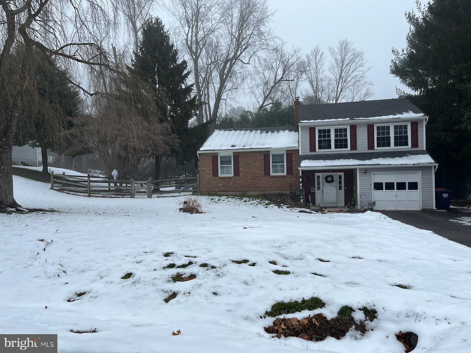 a front view of a house with a yard covered with snow in front of house