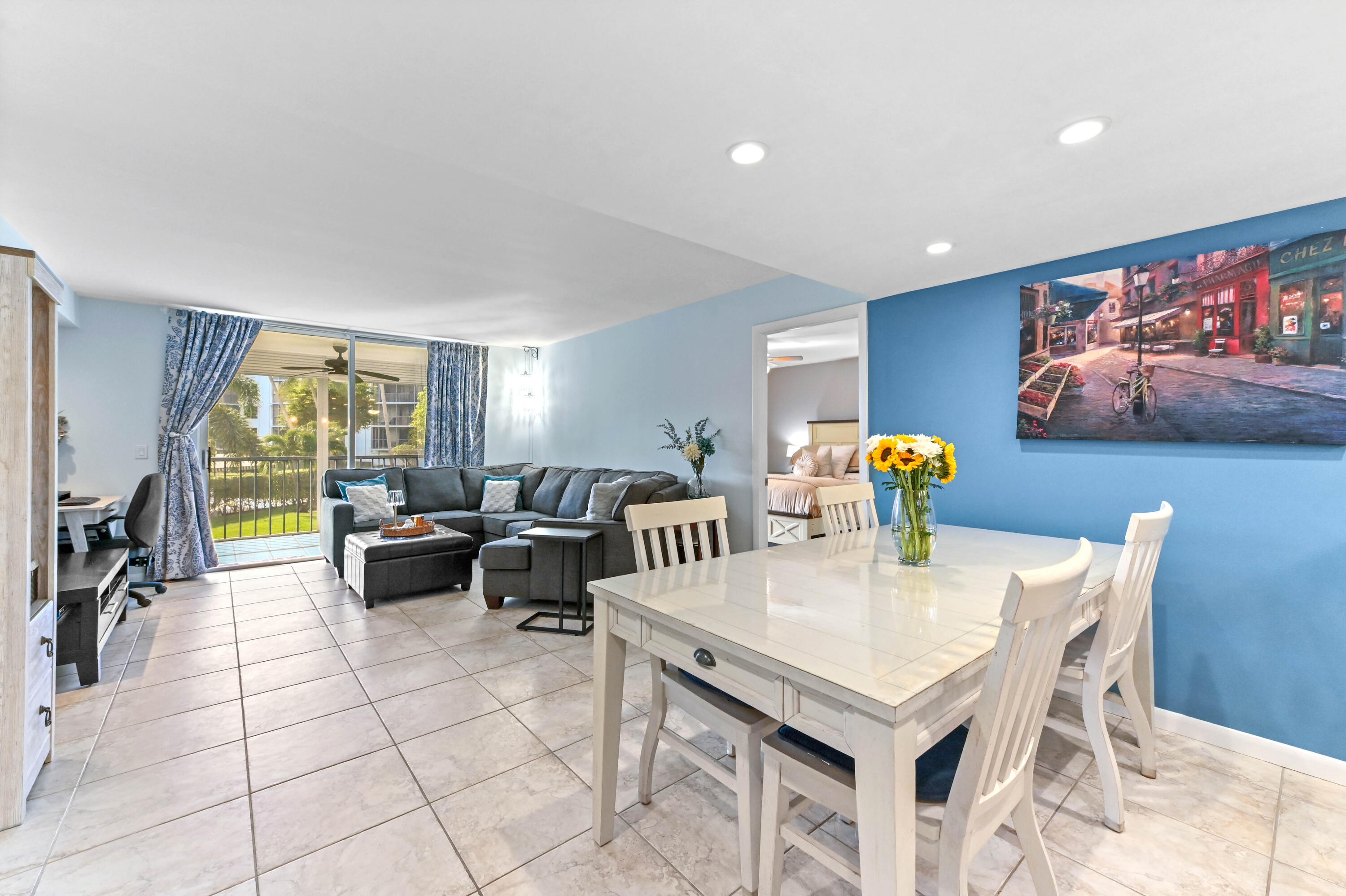 198 Northwest 67th Street, Unit 207 Boca Raton, FL 33487 - Photo 13 of 43 a view of a dining room and livingroom with furniture a rug a flat screen tv and a large window