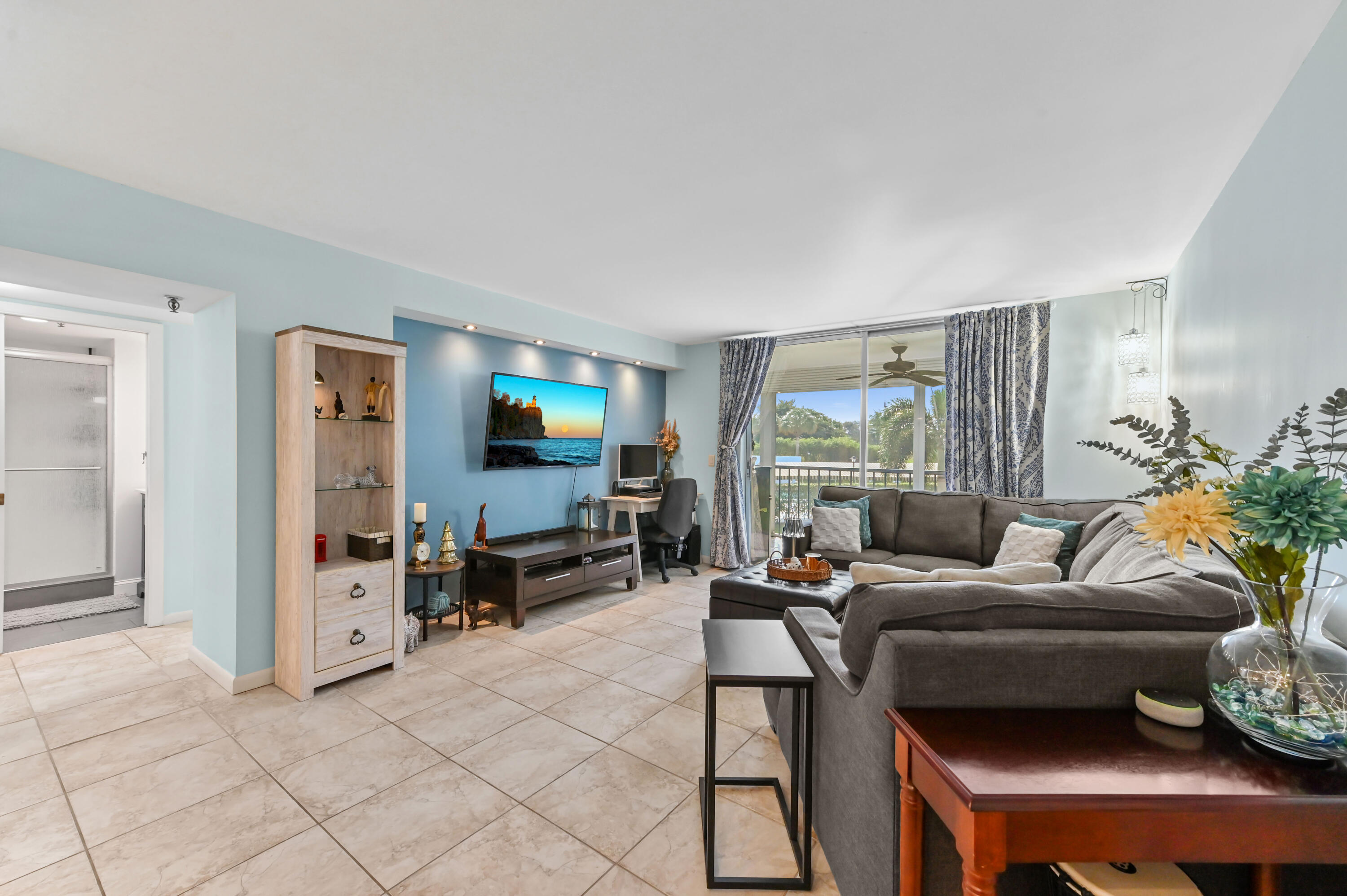 198 Northwest 67th Street, Unit 207 Boca Raton, FL 33487 - Photo 17 of 43 a living room with furniture and a flat screen tv