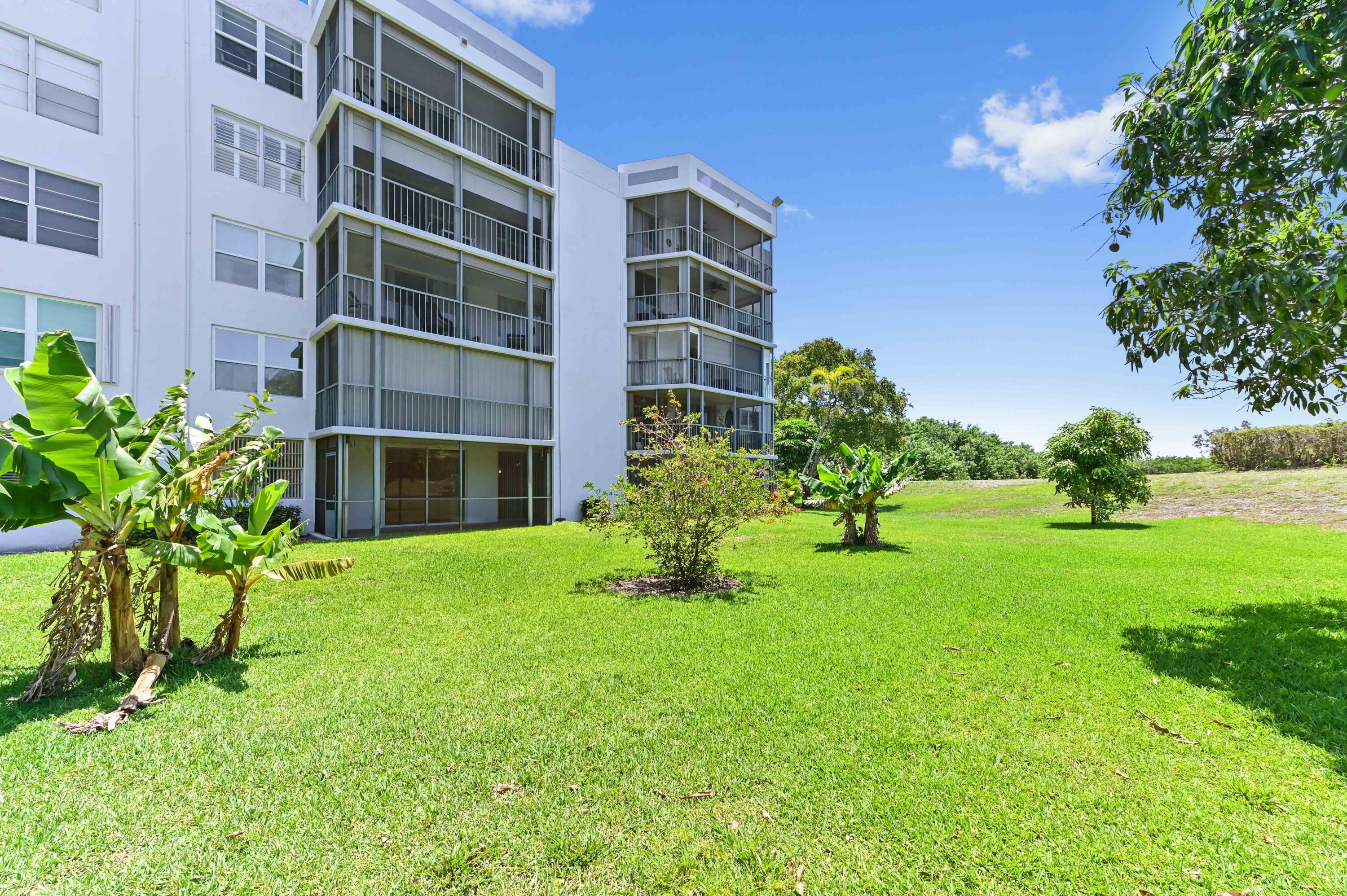 198 Northwest 67th Street, Unit 207 Boca Raton, FL 33487 - Photo 37 of 43 a view of a garden with a building in the background