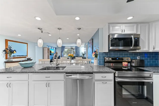 a kitchen with stainless steel appliances granite countertop a sink and cabinets