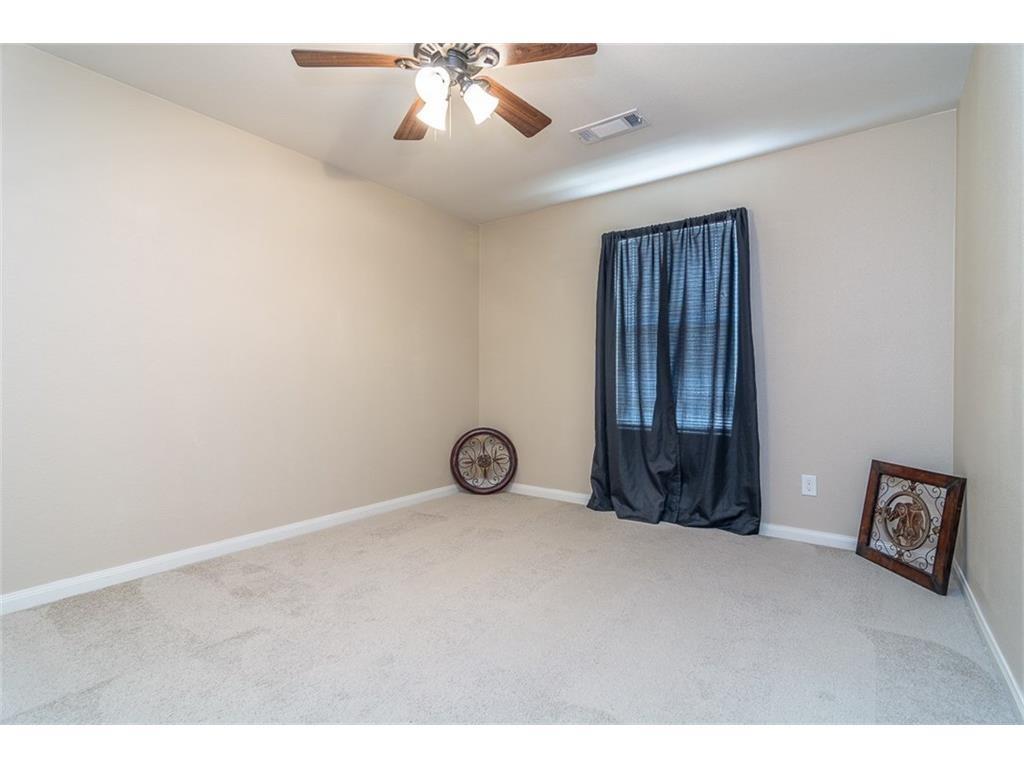 1009 Hawthorne Road Anna, TX 75409 - Photo 2 of 22 Spacious room featuring neutral carpeting, light beige walls, a window with blinds, and a ceiling fan with light fixture
