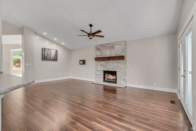 2154 Wasatch Boulevard Sandy, UT 84092 - Photo 21 of 55 Unfurnished living room with lofted ceiling, a fireplace, dark wood-style floors, a ceiling fan, and recessed lighting