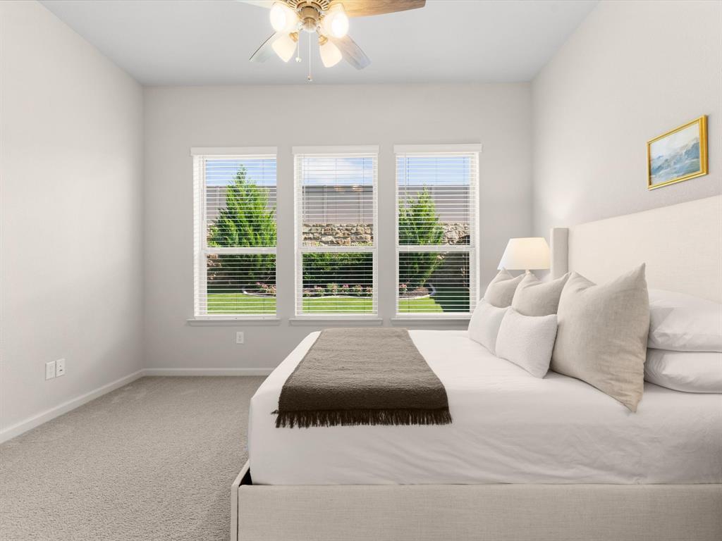 166 Palo Duro Bend Rhome, TX 76078 - Photo 21 of 40 Primary bedroom offering comfort, natural light, and views of the backyard.