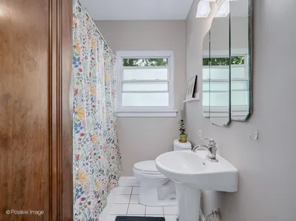 a bathroom with a sink a toilet and a window