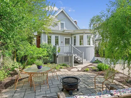 a view of a house with backyard and sitting area