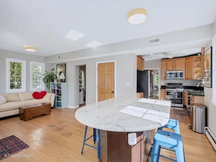 a living room with stainless steel appliances furniture a dining table and chairs