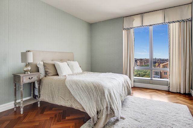 a bedroom with a bed and a large window