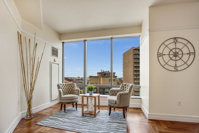 a living room with furniture a large window and wooden floor