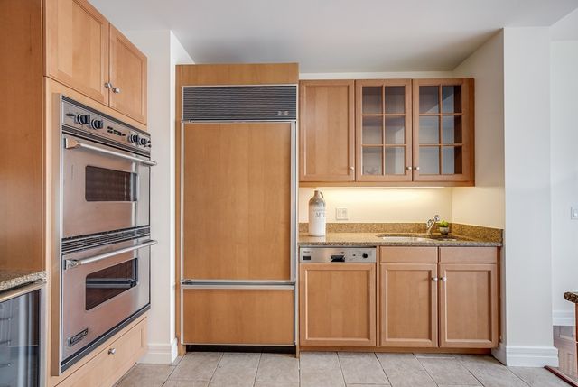 a kitchen with stainless steel appliances granite countertop a refrigerator and a stove