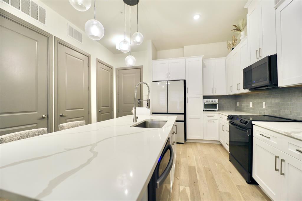 a large white kitchen with a stove a sink and a refrigerator