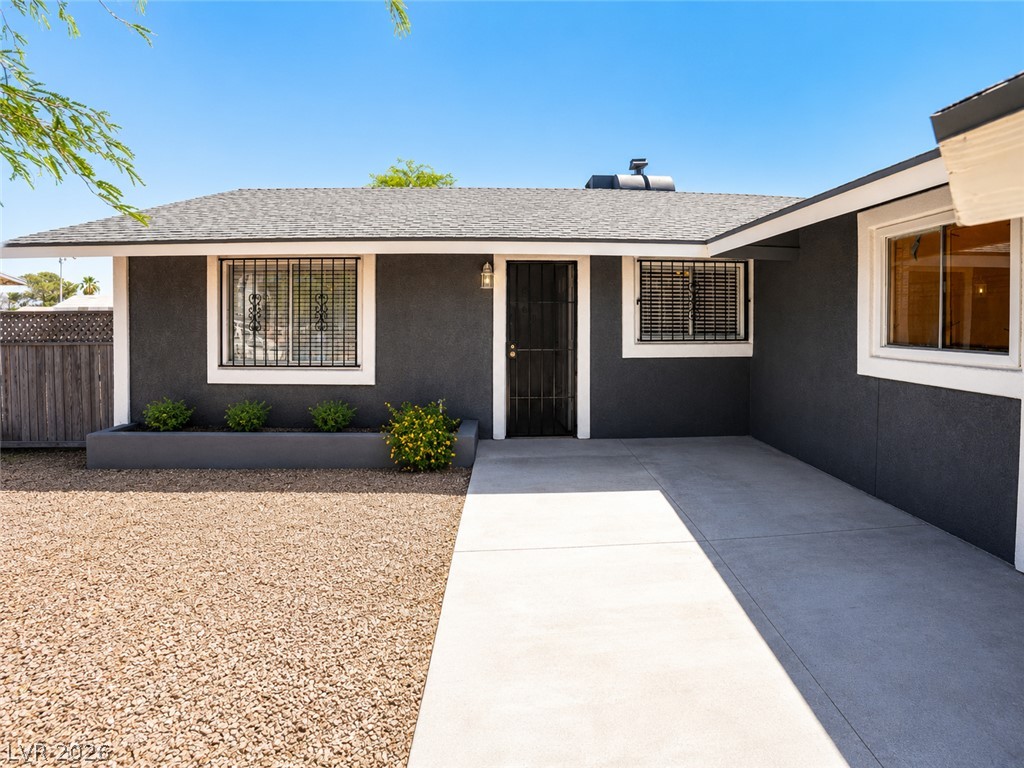 2870 South Sandhill Road Las Vegas, NV 89121 - Photo 4 of 64 Well-maintained dark exterior with a stone bed and a smooth concrete path leading to the entrance.