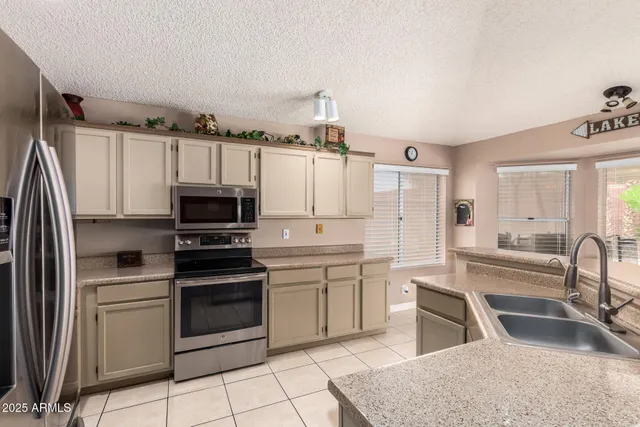 a kitchen with granite countertop a sink appliances and cabinets