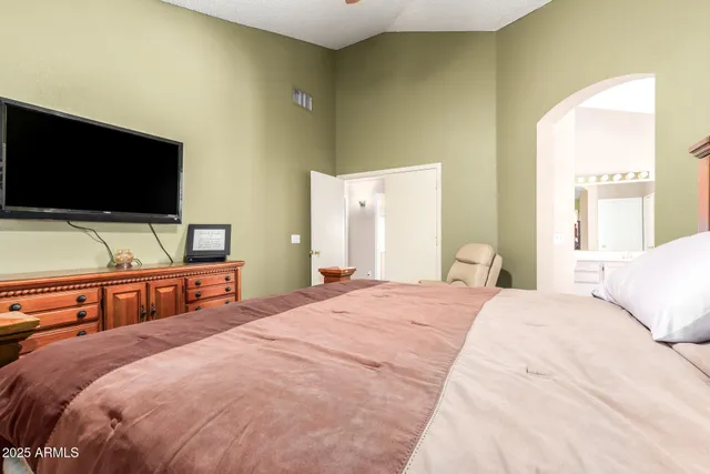 a bedroom with a bed and a flat screen tv