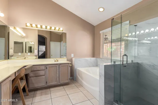 a spacious bathroom with a granite countertop sink a large mirror and a bathtub