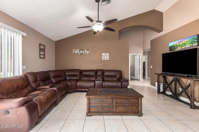 a living room with couches a coffee table and a flat screen tv