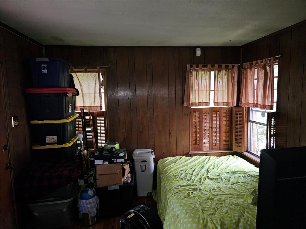 2714 Crest Ridge Drive Dallas, TX 75228 - Photo 10 of 15 Room featuring wood-finish paneling, multiple windows with louvered shutters, and a white ceiling