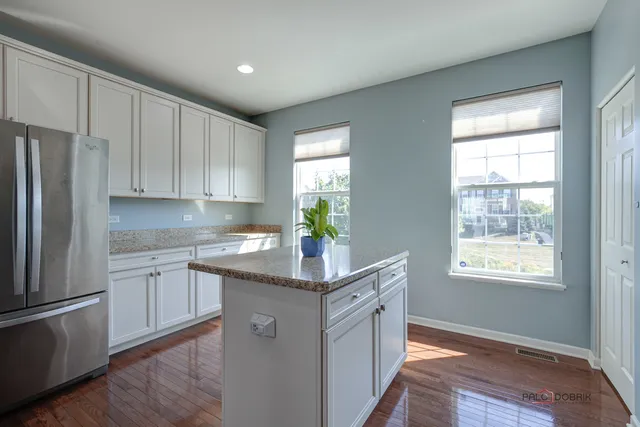 a kitchen with kitchen island granite countertop a sink appliances cabinets and a counter top space
