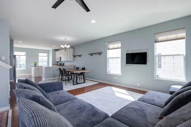 a living room with furniture and a dining table with kitchen view