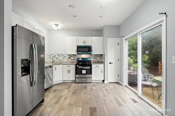 a kitchen with stainless steel appliances a refrigerator and a stove top oven