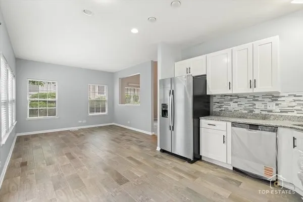a kitchen with stainless steel appliances granite countertop a refrigerator and a stove top oven