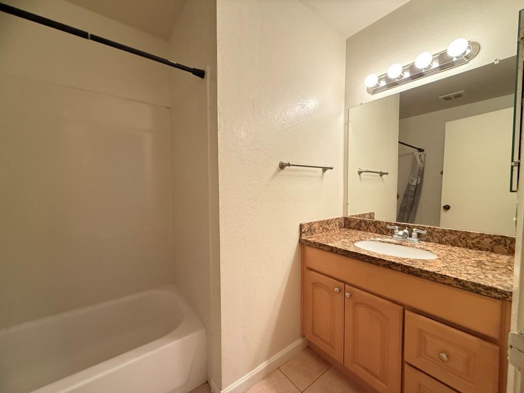 20072 Northcrest Square Cupertino, CA 95014 - Photo 12 of 26 a bathroom with a granite countertop sink a mirror a vanity and a bathtub