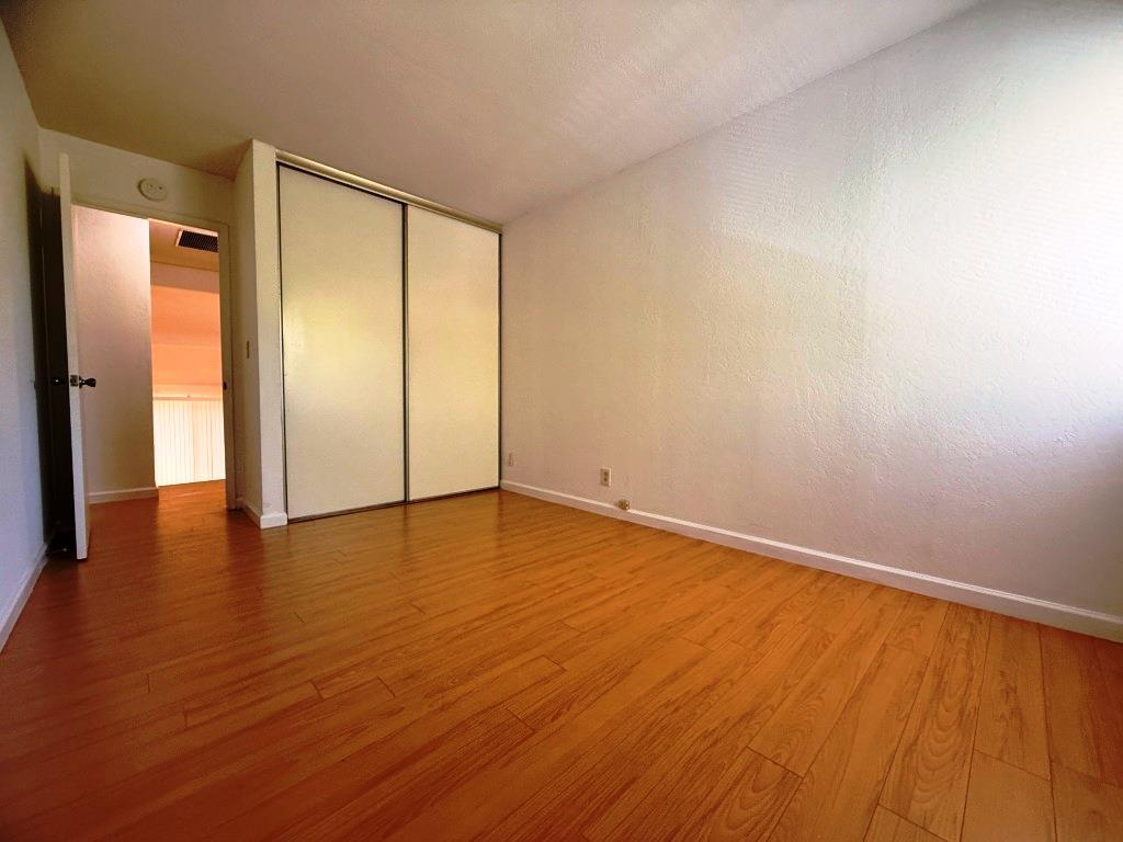20072 Northcrest Square Cupertino, CA 95014 - Photo 13 of 26 a view of an empty room with wooden floor and a window