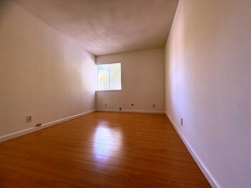 20072 Northcrest Square Cupertino, CA 95014 - Photo 14 of 26 an empty room with wooden floor and windows