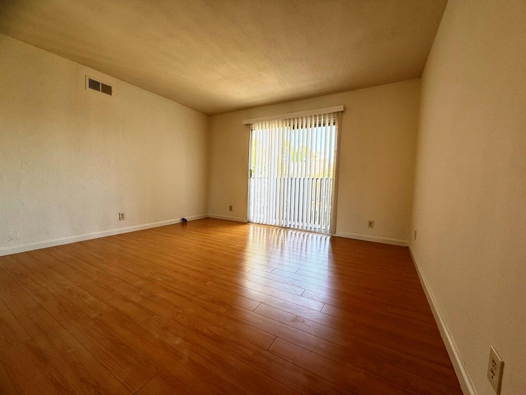 20072 Northcrest Square Cupertino, CA 95014 - Photo 9 of 26 an empty room with wooden floor and windows