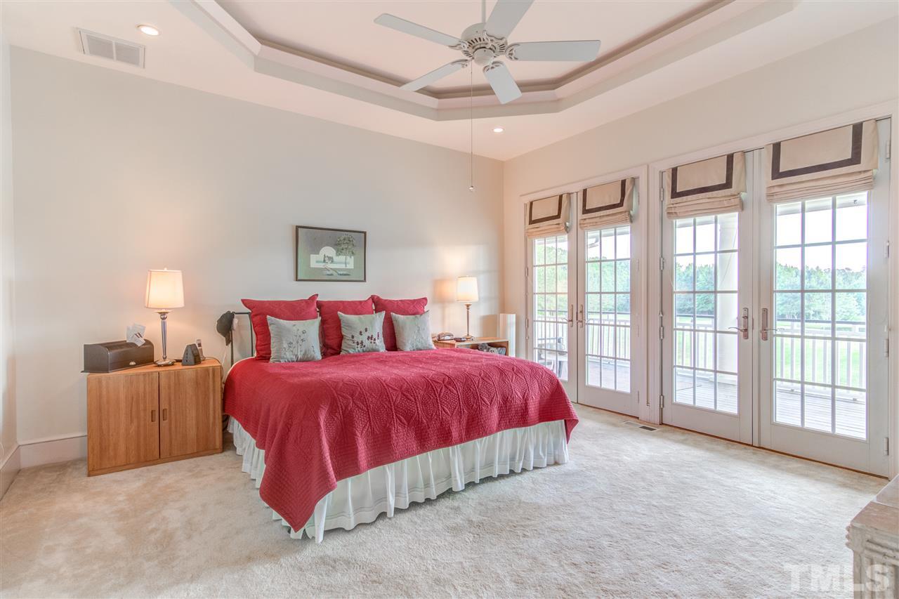 703 Kirk Adams Road Angier, NC 27501 - Photo 16 of 25 Master Suite in the back of the home offers more wall to wall windows and French Doors leading out to the back porch with pond views.
