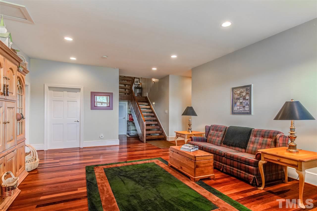703 Kirk Adams Road Angier, NC 27501 - Photo 21 of 25 Full daylight basement offers tons of storage closets and this rec room with more of those sturdy teak floors. Hallway leads to another living space currently being used as an office, and another full bathroom and bedroom. Access to the garage as well!
