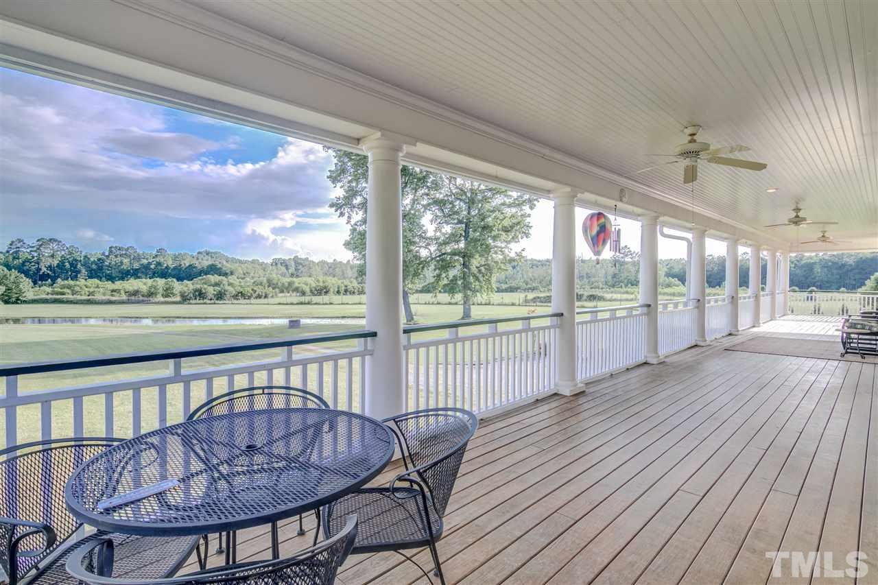 703 Kirk Adams Road Angier, NC 27501 - Photo 23 of 25 72 feet of porch on the back of the home with lovely pond views!