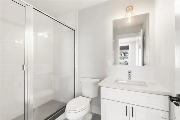 a bathroom with a sink a mirror a toilet and shower
