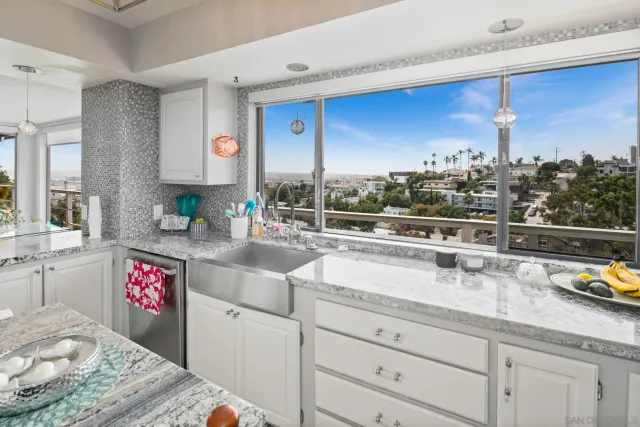 a kitchen with stainless steel appliances granite countertop a sink a stove and a wooden cabinets