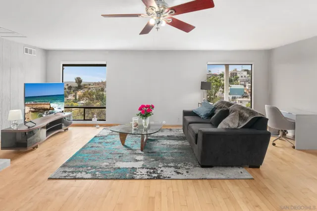 a living room with furniture and a kitchen area