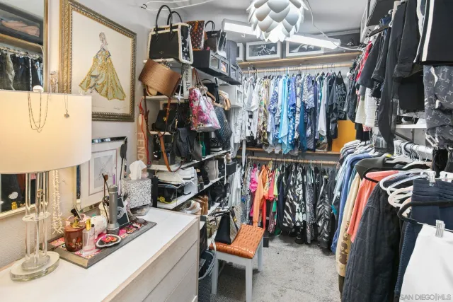 a view of walk in closet with clothes and shoes