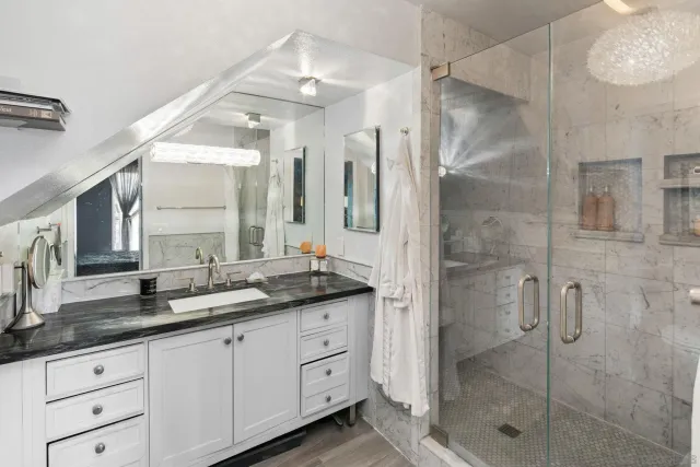 a bathroom with a granite countertop sink mirror and shower