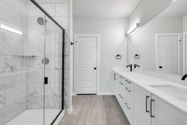 a spacious bathroom with a double vanity sink and mirror